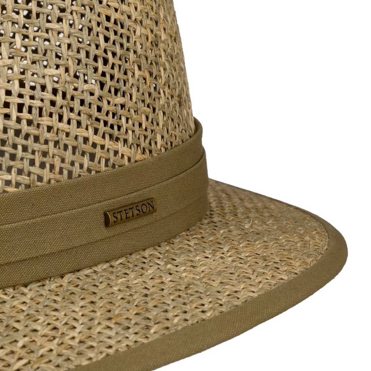 Close-up of a woven seagrass Traveller hat with a tan band featuring a Stetson logo patch, on a white background.