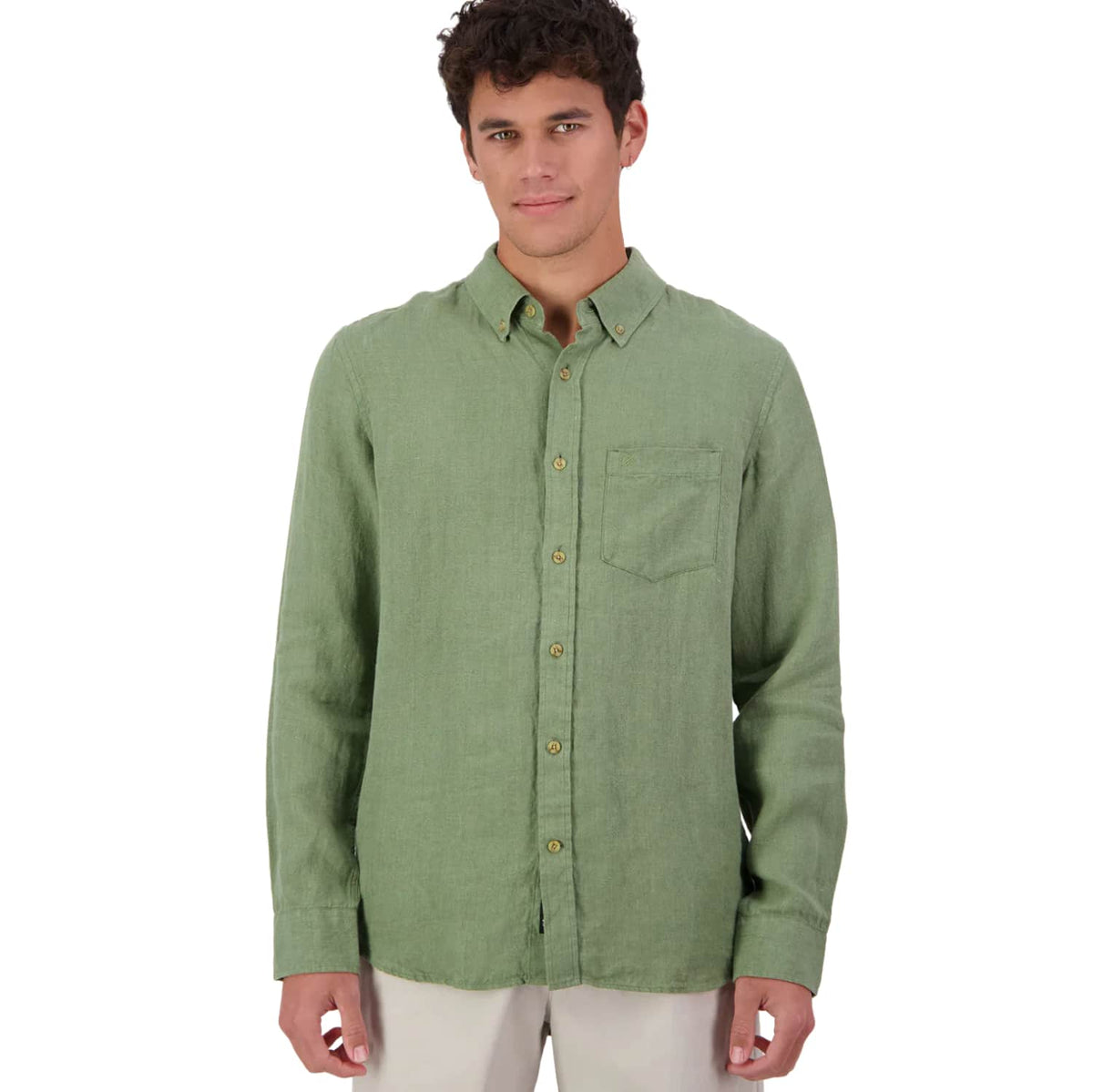 A man wearing a Swanndri light sage green long-sleeve linen button-up shirt with a chest pocket, paired with off-white trousers, against a plain white background.