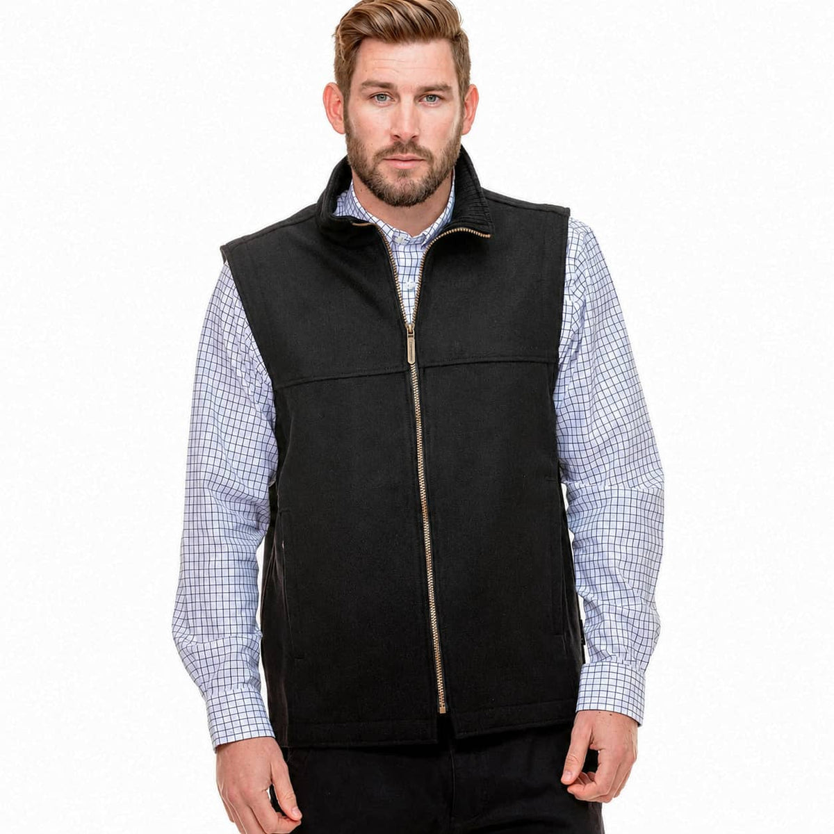 A man wearing a black zip-up fleece vest over a light blue and white checkered long-sleeve shirt, photographed against a plain white background.