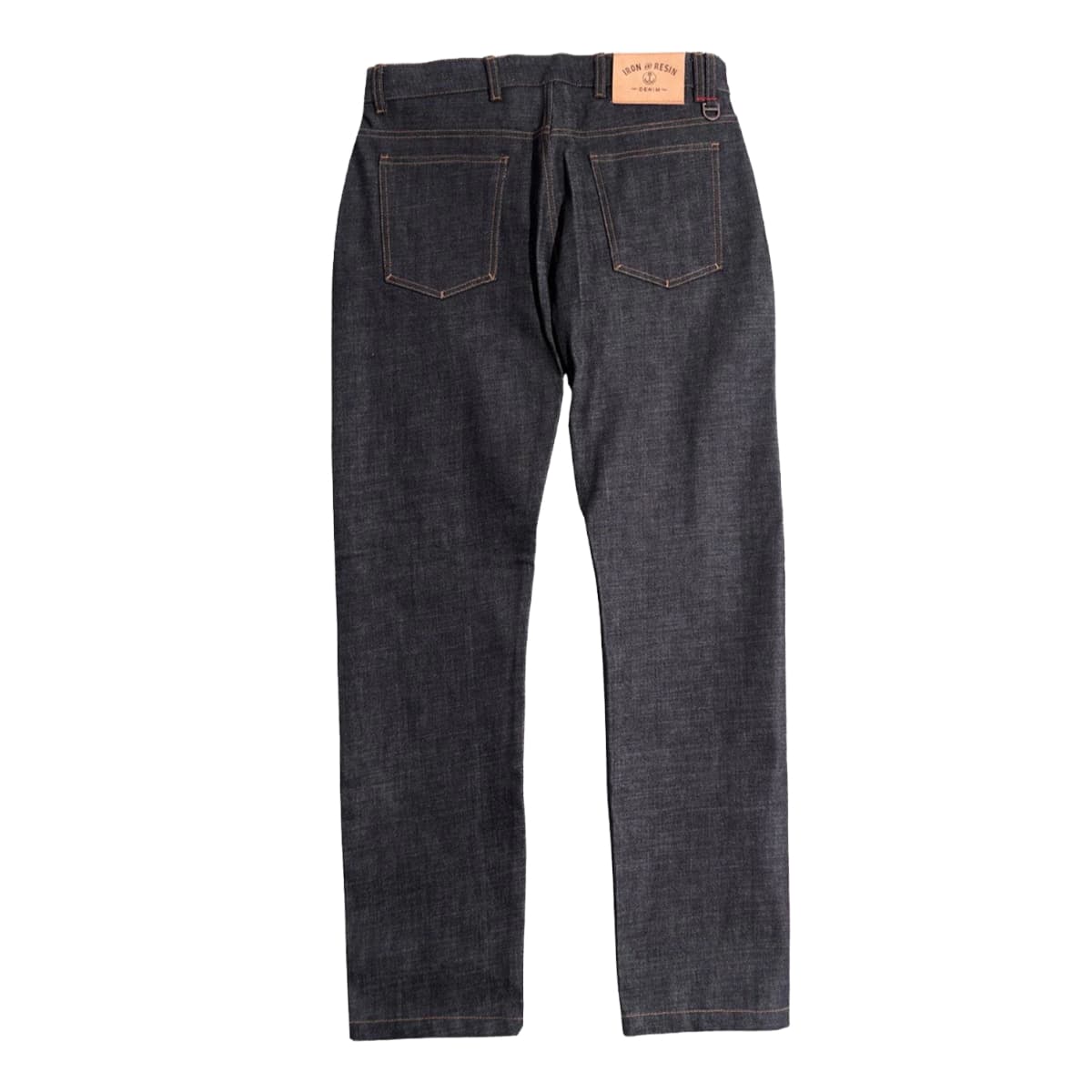 Back view of dark indigo denim jeans with a tan leather brand patch on the waistband, displayed against a solid white background.