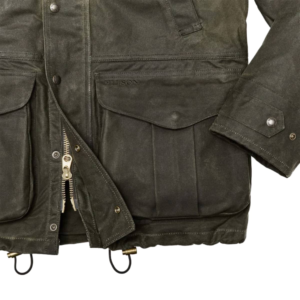 Close-up of a Filson Tin Cloth Field Jacket with multiple flap pockets, metal snap buttons, and brass zipper hardware on a white background.