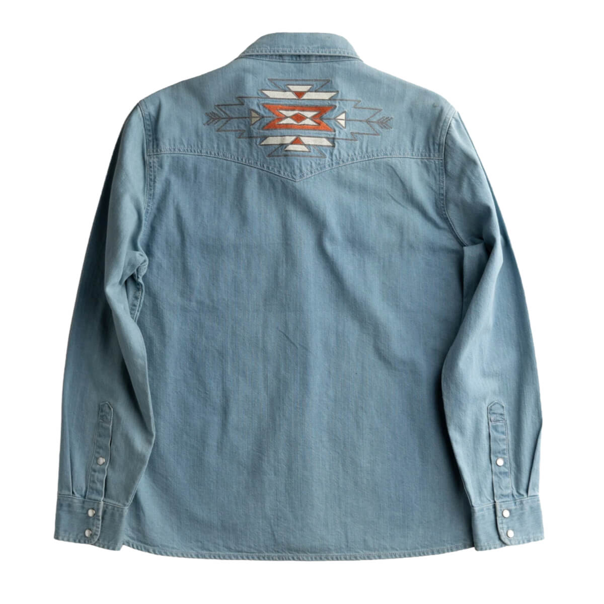 Blue denim shirt with a geometric pattern on the back against a white background