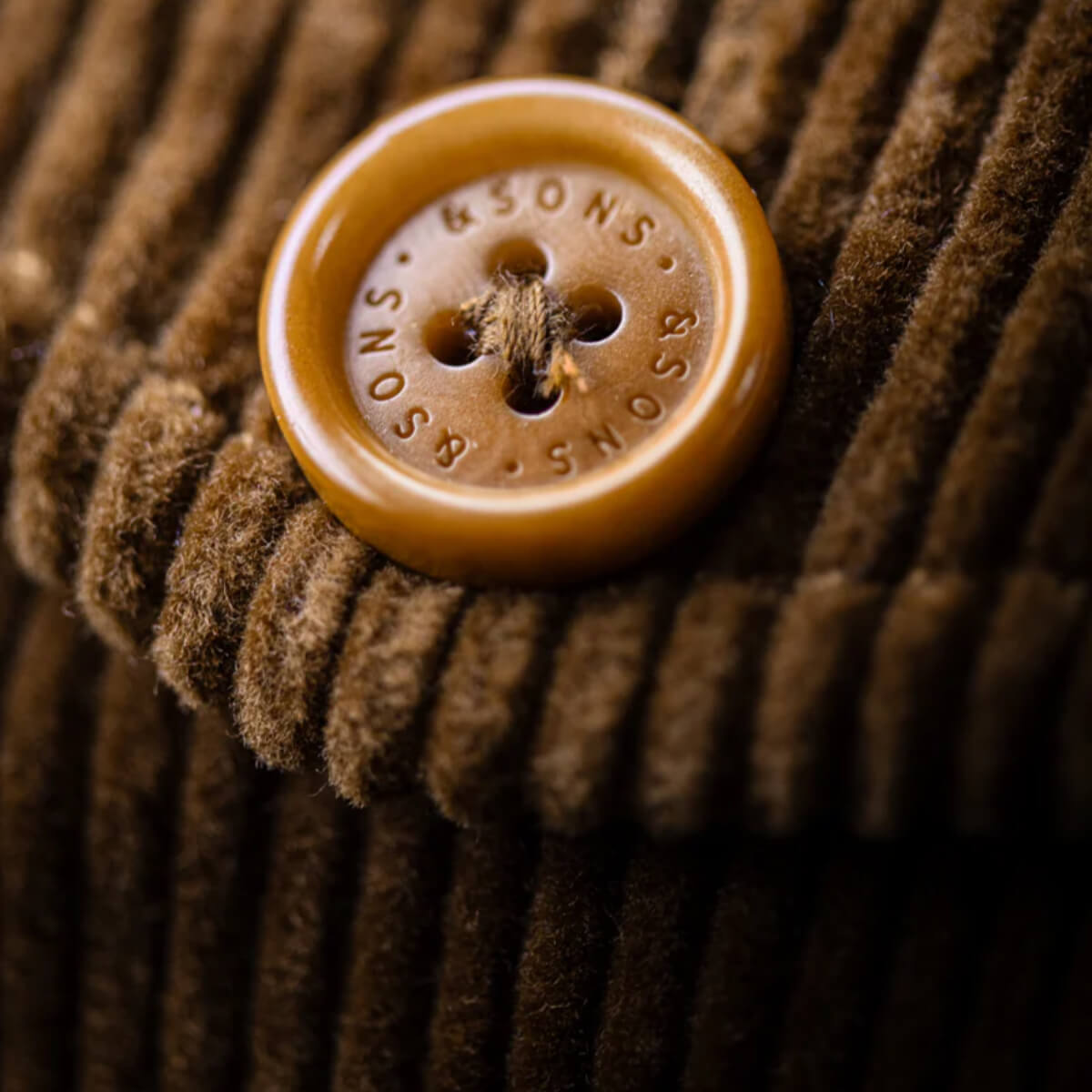 Close-up of a brown button on a textured fabric background