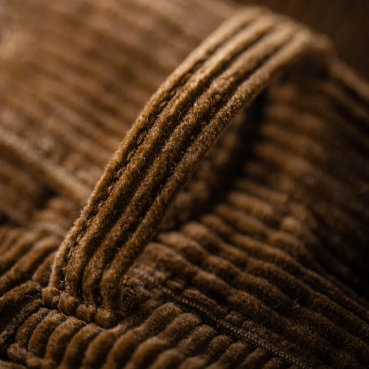 Close-up of brown corduroy fabric with a focus on texture.