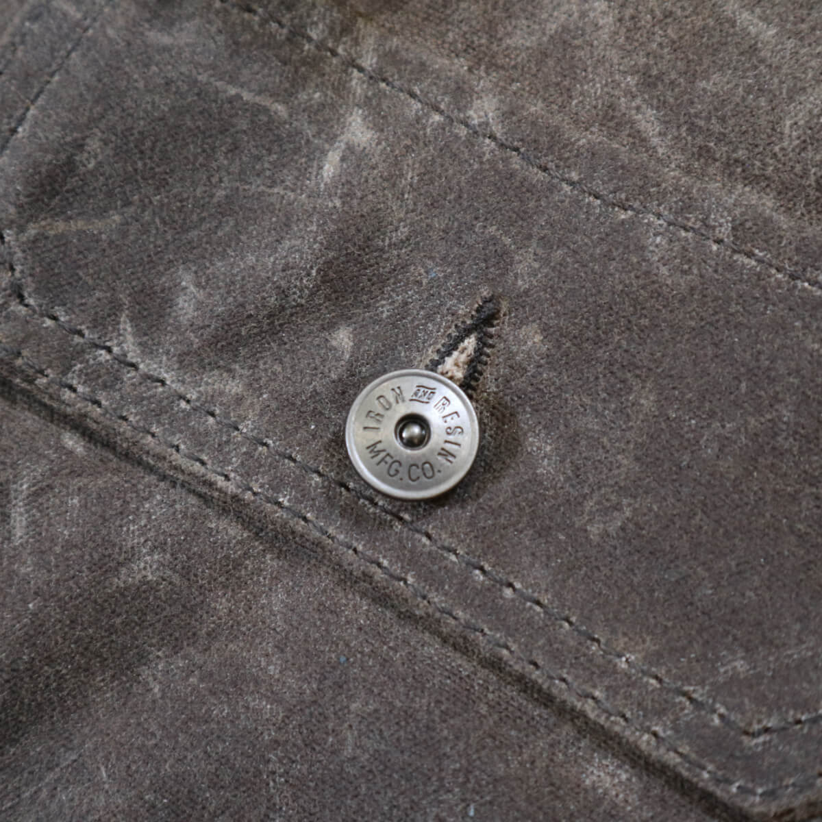 Close-up of a button on a textured gray fabric surface