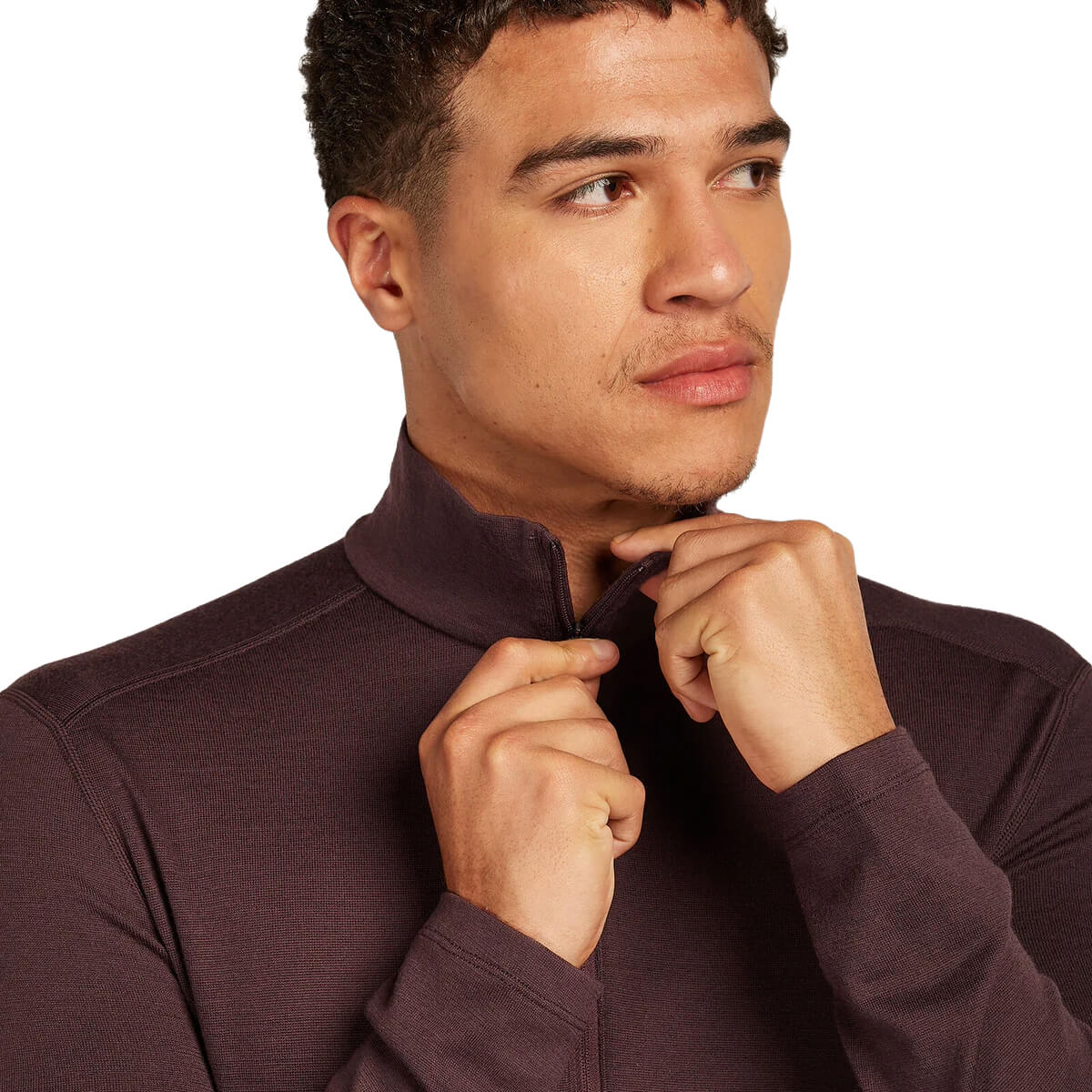 Man adjusting his collar on a plain background