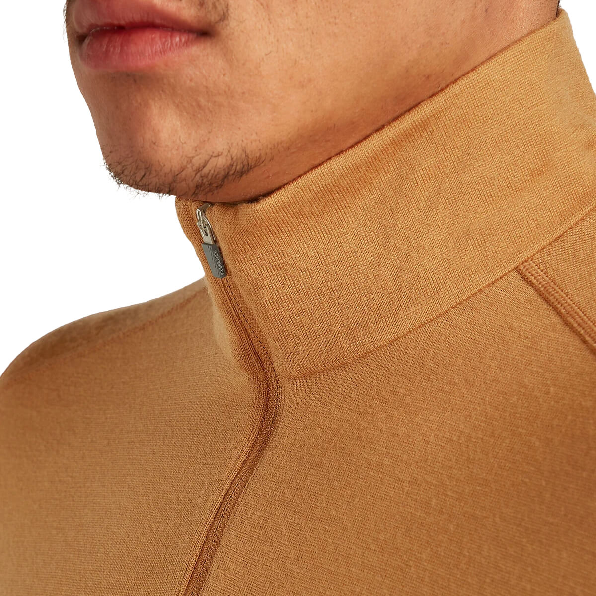 Close-up of a person wearing a brown turtleneck sweater with a zipper.