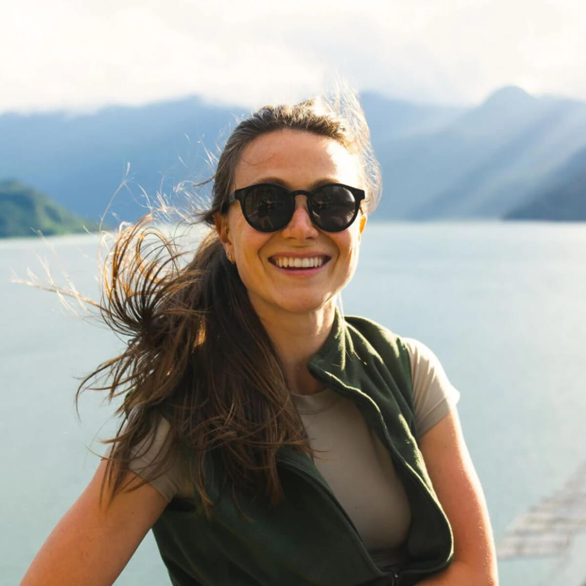 Woman wearing sunglasses with mountains in the background